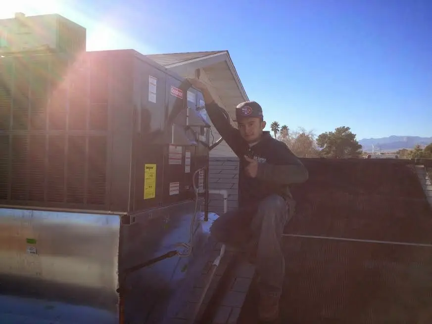 HVAC technician performing HVAC Inspection on a rooftop unit in Orland